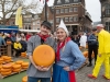 Niederlande, Gouda, 10.04.2025Der Kaesemarkt von Gouda ist ein spektakulaeres historisches Schauspiel, das vom 4. April bis zum 29. August jeden Donnerstagvormittag stattfindet. Vor der Waage handeln die Landwirte mit den Haendlern die Preise aus. Und so wie es seit Jahrhunderten Brauch ist, wird der Verkauf immer noch per Handschlag besiegelt. Foto: Kaesejunge und Kaesemaedchen mit einem Kaeselaib[Copyright by: Sepp Spiegl, Tel.: 0228 9483026, Fax.: 0228 9483027 {53129 Bonn, Moselweg 32, Deutsche Bank-Bonn, IBAN: DE66 3807 0059 0314 9671 01, BIC.: DEUTDEDK380]